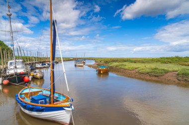 Blakeney, Kuzey Norfolk, İngiltere 'deki Glaven Nehri' ndeki renkli tekneler.