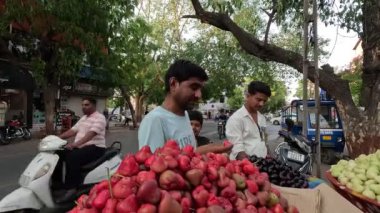 Hintli satıcı pazarda taze liçi, kiraz ve kırmızı elma meyveleri satıyor.