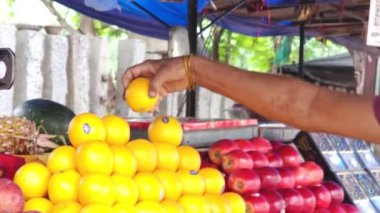 Kadının eli meyveyi tutuyor.