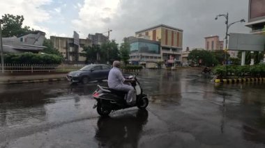 Devam eden yağmurda araçlar su dolu yoldan ayrılıyor.