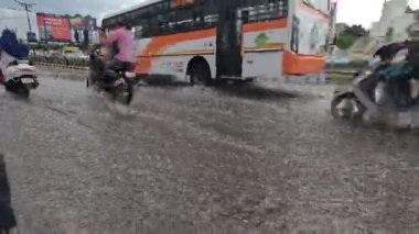 Devam eden yağmurda araçlar su dolu yoldan ayrılıyor.