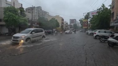 Devam eden yağmurda araçlar su dolu yoldan ayrılıyor.