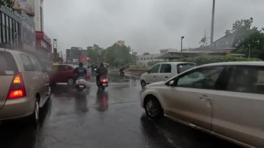 Devam eden yağmurda araçlar su dolu yoldan ayrılıyor.