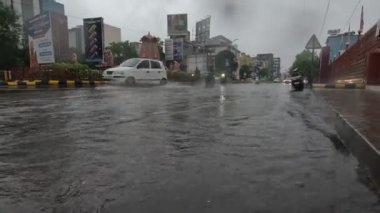 Devam eden yağmurda araçlar su dolu yoldan ayrılıyor.