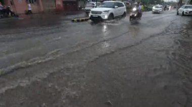 Devam eden yağmurda araçlar su dolu yoldan ayrılıyor.