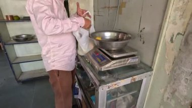 Mangoları tartıp paketleyen adam çok müşteri. 