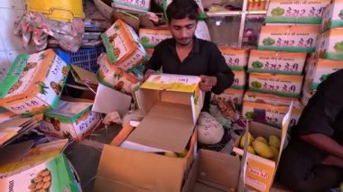 Bir kutu Alphonso mangosunu paketleyen bir adam.