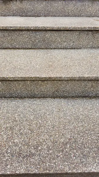 Yerde gri ve kahverengi çizgileri olan granit bir doku.