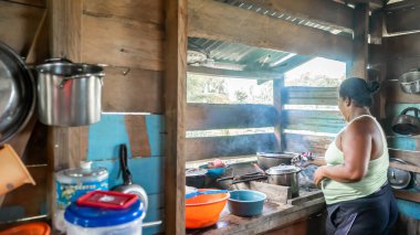 Orta Amerika, Nikaragua 'daki mütevazı ahşap evinde yemek pişiren Afro-Karayipli kadın.