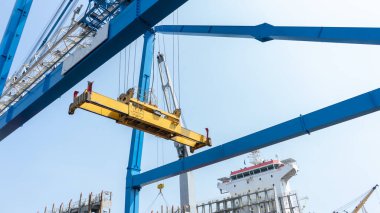 Endüstriyel yük vinci, uluslararası bir gemiye ihracat ve ithalat için ürünleri yüklemeye hazır.