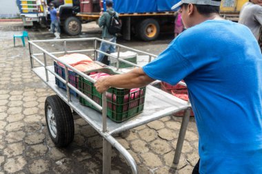 Managua, Nikaragua 'da bir pazarın caddelerinde el arabasıyla dolaşan tanınmayan bir perakendeci görülüyor.