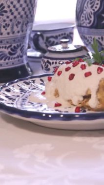 Orijinal Meksika yemeği, Chiles en Nogada, geleneksel talavera kil tabağında servis edilen beyaz ceviz sosu ve nar ile doldurulmuş poblano biberi..