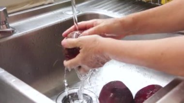 Kıdemli Meksikalı kadın pancar köklerini her gün akan suyla yıkıyor..