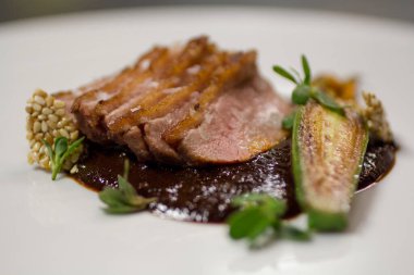 Baharatlı Köstebek soslu ızgara ördek göğsü dilimleri ve yakın plan kızarmış kabak..