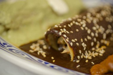 Meksika enchilada soslu dürüm sosuyla kaplanmış ve üstü kızarmış susam tohumuyla kaplanmış..