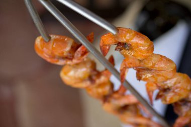 Golden grilled shrimp on Brazilian-style skewer, close-up. clipart