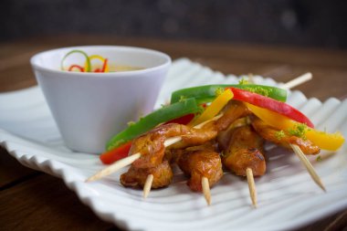 Kavrulmuş dolmalık biberli, limonlu ve baharatlı mayonezli tavuk şiş, koyu bulanık arka planda ayarlanmış düşük açılı..