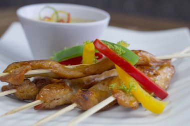 Kavrulmuş dolmalık biberli, limonlu ve baharatlı mayonezli tavuk şiş, koyu bulanık arka planda ayarlanmış düşük açılı..