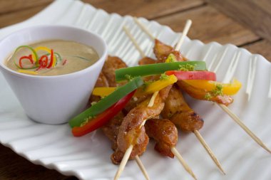 Lezzetli limon garnitürle kaplanmış ve baharatlı mayonezle servis edilmiş canlı kavrulmuş dolma biberli yüksek açılı tavuk şişleri..