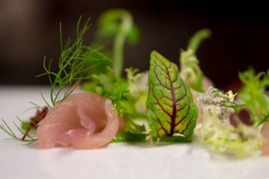 Tütsülenmiş pembe somon carpaccio, yenilebilir çiçekler, mikro yeşiller, yakın plan Kuzey salatası..