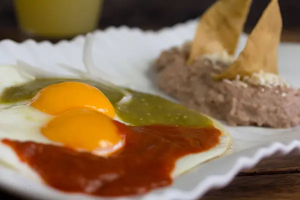 Klasik huevos rancheros ve chipotle ve serrano biber sosu, siyah fasulye ve tortilla cipsi..