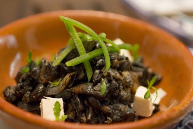 Roasted corn fungus Huitlacoche with cheese dices and jalapeno pepper, side view close-up. clipart