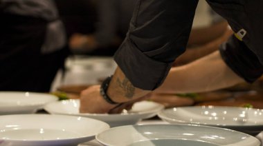 Şefler güzel bir yemek mutfağındaki tabakları dikkatlice tabağa koyarlar..