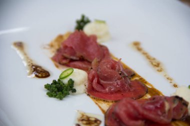 Kavrulmuş karnabahar ve acı biber dilimleri ile modern sığır carpaccio, lezzetlerin birleşimi..