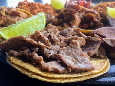 Bir dilim limonlu mısır tortilla üzerine sulu bir carne asada taco, rafine bir sokak yemeği seti.