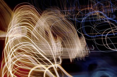 Soyut uzun pozlama ışık yolları altın iplikler oluşturarak ve canlı renk patlamaları, kasıtlı kamera hareketi ile yakalandı.