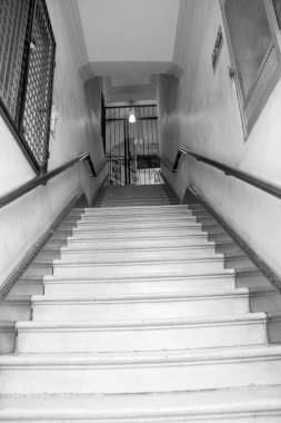 Meksika, Puebla 'daki kırsal bir merdivenin siyah beyaz manzarası dövmeli demir bir kapıya çıkıyor ve tarihi bir şehir ortamında günlük hayatı yakalıyor..