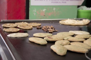 Geleneksel Meksikalı tilkiler dökme demir bir kuyruklu yıldızla yemek pişiriyorlar. Otantik mısır koçanı atıştırmalıkları, altın dokular ve zanaatkar sokak yemekleri hazırlama..