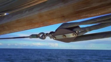 Kaliteli ahşap kayık makarası ve ipler. Açık denizde eski bir yelkenlinin kefenleri ve ipleri. Yelkenli teknenin yan ipleri. Yavaş çekim videosu. N. Yüksek kaliteli FullHD ProRes görüntüleri