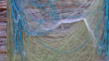 Fishing nets are drying on the wall of an old wooden house. Traditional fishing tools.