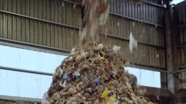 Garbage in a moving Conveyor. Wast Recycling Plant. Bad quality organic waste with an admixture of plastic and household waste. Garbage falls into a pile before sorting.