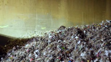Heap of organic waste at compost recycling station. Bad quality organic waste polluted with plastic garbage at city waste management plant.