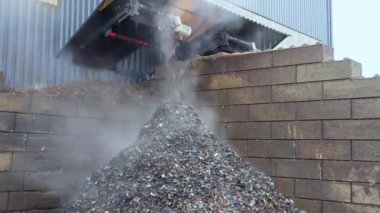 Poor quality bio-waste falls into a pile before the final recycling. Bio-waste dump and recycling. Fuming biowaste. High quality 4k footage