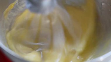 Mixing raw eggs in a silver kitchen stand mixer. Whipping the eggs. Slow motion video, Selective focus. High quality 4k ProRes footage