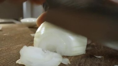 Close-up slow motion view of man cutting onion with knife. Male hands of chef cooking. Healthy lifestyle, vegetables. Slicing onions. Selective focus.