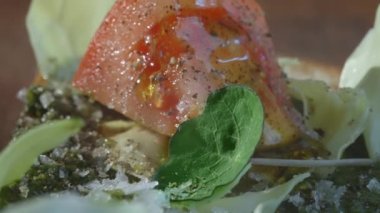 Preparing food in kitchen. Vegetarian sandwich. Chef pours olive oil over sandwich with cheese, tomatoes, cabbage, watercress and pesto. Selective focus. Slow motion video. High quality 4k footage