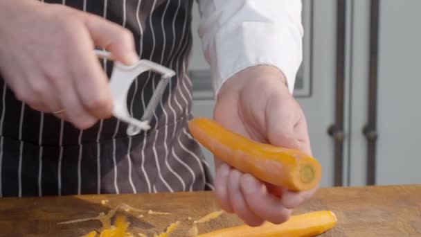 Der Koch Schält Gerade Die Karotte Mans Hände Schälen Gemüse — Stockvideo