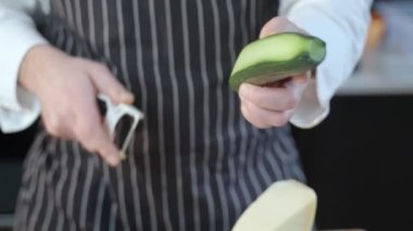 The cook cuts the cucumber into long slices. High quality 4k footage