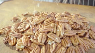 Grating pecans. pecan spice. Slow motion video. The spices fall slowly on the kitchen board. High quality 4k footage