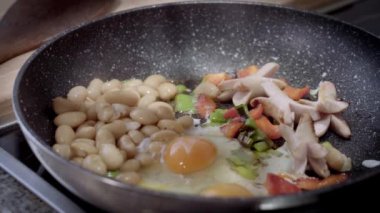 İngiliz kahvaltısı. Kızartma tavasında pişmiş yumurta. Fasulyeli yumurta, sosis ve tavada yeşillik..
