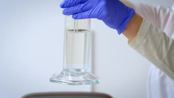 Een Vloeistof Mengen Een Laboratoriumcilinder Een Vrouw Roert Een Chemische — Stockvideo