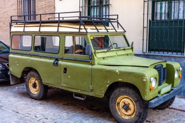 Portekiz sokaklarında eski, yeşil klasik bir araba. Klasik Land Rover Defender. Nadir bir araba örneği. Tahsilat arabası. Yüksek kalite fotoğraf