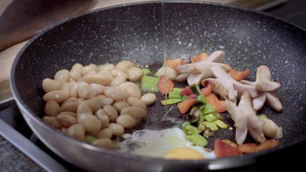 英式早餐在煎锅里准备煎蛋 炒锅里的炒鸡蛋和豆子 腊肠和青菜 — 图库视频影像