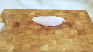 Bir şefin ellerini kesme tahtasının üzerinde tavuk göğsü keserken yaklaş. Seçici odaklanma. Yavaş çekim videosu. Yüksek kaliteli FullHD görüntüler