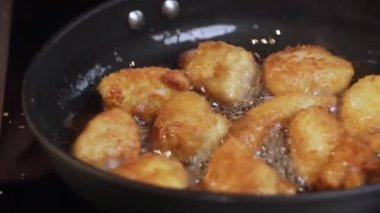 Yemek hazırlama. Kızartma makinesinde tavuk nugget hazırlığı. Kızarmış tavuğu kızgın yağda kızartma işlemi.