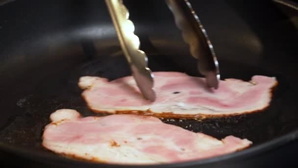 베이컨 슬라이스를 튀기는 맛있는 스모키 베이컨 뜨거운 튀겼다 연기가 베이컨 — 비디오